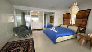 a bedroom with a large bed and a chair at Kata Top Villas in Kata Beach