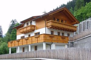 una casa con balcones de madera en la parte superior de una valla en Ferienhaus Enterberg, en Ramsau im Zillertal