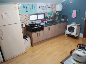 a kitchen with a refrigerator and a counter top at Uwha Minbak in Yeosu