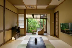 a living room with a table and a tv at Nazuna Kyoto Nijo-jo in Kyoto