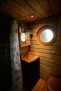 a small bathroom with a sink and a window at La Cabane aux Secrets - Au Milieu de Nulle Part in Outines