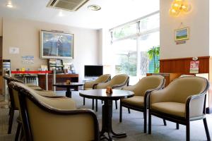 a waiting room with chairs and tables and a tv at Yamanakako-Asahigaoka-Onsen Hotel Seikei in Yamanakako