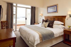 Habitación de hotel con cama grande y ventana en First Group Port Owen Marina, en Velddrif