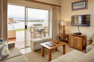 a living room with a couch and a tv at First Group Port Owen Marina in Velddrif