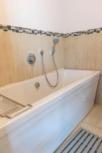 a bath tub with a shower in a bathroom at 18 on Tides End in Knysna