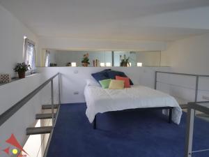 a bedroom with a bed with a blue carpet at CASAVELLINO: il tuo spazio moderno in centro in Avellino