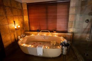 een badkamer met een bad met verlichting bij Elephant Plains Game Lodge in Sabi Sand Game Reserve