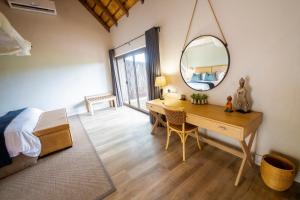 a bedroom with a desk and a mirror and a bed at Elephant Plains Game Lodge in Sabi Sand Game Reserve