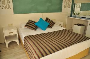 a bedroom with a large bed with blue pillows at Aura Boutique Hotel in Side