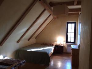 Zimmer im Dachgeschoss mit einem Bett und einem Fenster in der Unterkunft Dom koło Rewala in Paprotno