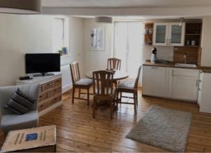 a living room with a kitchen and a table with chairs at Wohlfühl Appartments in Felsberg