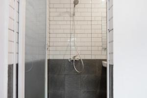 um chuveiro com uma porta de vidro na casa de banho em Super OYO 3150 Theodore Homestay em Medan