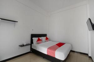 a bedroom with a bed with red and white pillows at SUPER OYO 3309 Forrest’inn in Kediri