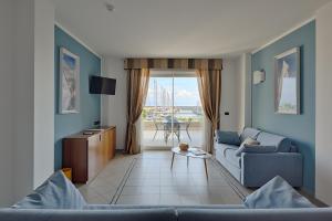 a living room with two couches and a table at Aregai Marina Hotel & Residence in Santo Stefano al Mare