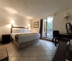 um quarto de hotel com uma cama e uma varanda em Hotel Del Portal, Puebla em Puebla