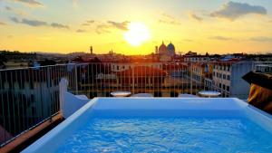 a hot tub on top of a balcony with the sunset at MyForte Relais de Charme & SPA in Florence