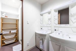 a white bathroom with a sink and a mirror at THE EAST AVENUE in Sapporo