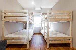 two bunk beds in a room with wooden floors at THE EAST AVENUE in Sapporo