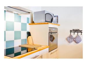 uma cozinha com um micro-ondas em cima de um fogão em La Bastide Saint Etienne em Cournanel