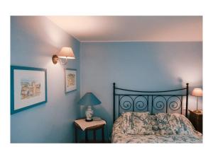 een slaapkamer met een bed en een tafel met een lamp bij La Bastide Saint Etienne in Cournanel
