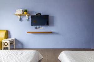 a room with two beds and a tv on a blue wall at Tropical island B&B in Xiaoliuqiu
