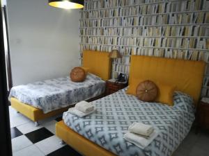 a bedroom with two beds and a book wall at Hotel Cristo Rei in Porto