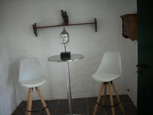 two white chairs and a table with a skull on it at Gästehaus MAXLTONI in Kitzeck im Sausal