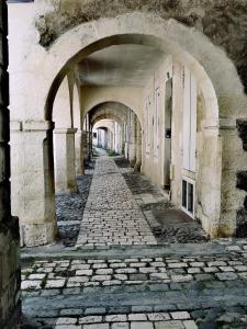 Une allée dans un vieux bâtiment avec une arche dans l'établissement La Belle Amarre-Bed and Breakfast-Maison d'Hôtes, à La Rochelle