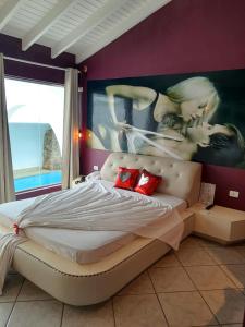 a bedroom with a bed and a large painting on the wall at Motel Ilha de Capri in São Bernardo do Campo