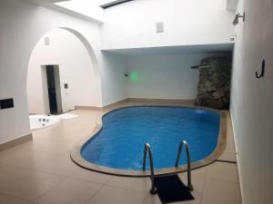 a large blue swimming pool in a room with an arch at Motel Ilha de Capri in São Bernardo do Campo
