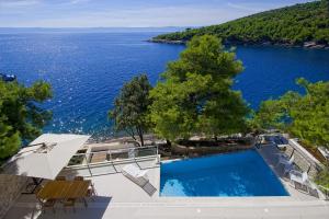 a swimming pool with a view of the water at Luxury Seafront Villa My Dream with private pool, jacuzzi and staff at the beach on Brac island - Sumartin in Selca