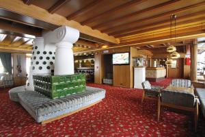 a large room with a couch and a tv in it at Hotel Grohmann in Campitello di Fassa