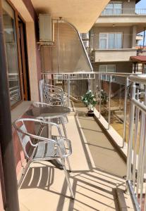 a balcony with tables and chairs on a building at Hotel Silver in Sozopol