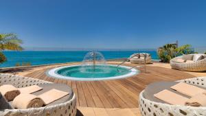 una piscina con una fuente en una terraza con sillas en XQ El Palacete, en Morro del Jable
