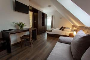 um quarto de hotel com uma cama e uma secretária com um sofá em Smrekarjeva Domačija em Postojna