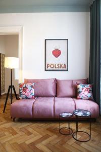 a living room with a purple couch with two tables at Classic apartments Pilsudskiego street in Kraków