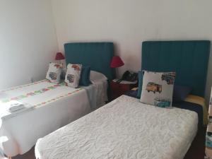 a bedroom with two beds with blue headboards at Hotel Cristo Rei in Porto