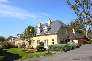 una gran casa amarilla con techo negro en Faithlegg Self Catering Mews, en Waterford