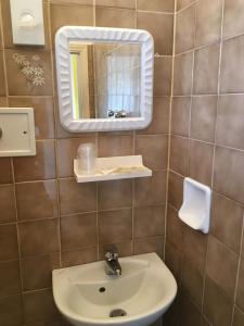 里米尼的住宿－Hotel Villa Rinaldini，一间带水槽和镜子的浴室