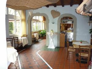 a restaurant with tables and chairs and a kitchen at Abakus-Hotel in Sindelfingen