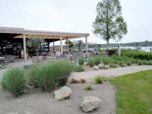 a patio with tables and chairs and rocks in a park at Hausboot Leukermeer Well in Well