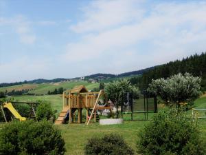 a playground in a field with a wooden house at Zukaunighof in Diex