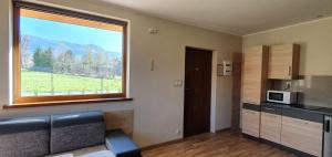 una stanza con cucina con una grande finestra di Domek w Karkonoszach 2 a Ściegny