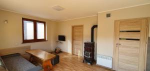 a living room with a wooden door and a table at Domek w Karkonoszach 2 in Ściegny