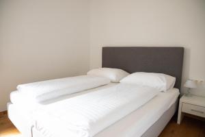 dwie białe poduszki siedzące na łóżku w obiekcie Appartements Freiraum w Schladming