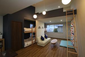 a room with bunk beds and a couch and a chair at Tiz wan 岩屋あわじ in Awaji