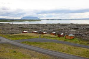 a road next to a body of water with houses at Hlíd Huts in Myvatn
