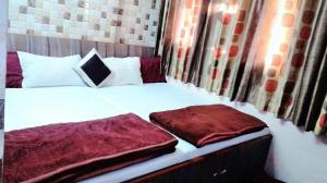 een slaapkamer met een wit bed met rode lakens bij Ajanta Hotel 100 Mtrs Railway Station & 400 Mtrs Dargah in Ajmer