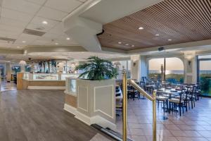 um restaurante com mesas e cadeiras e um bar em Princess Royale Oceanfront Resort em Ocean City