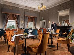 a man standing in a restaurant with tables and chairs at Faithlegg Self Catering Mews in Waterford